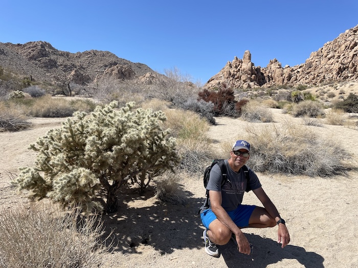 Empty two-lane road stretching through desert hills at sunset